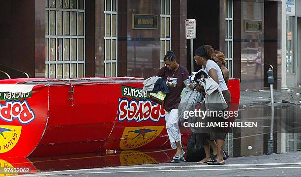 Looters hurry down Canal Street 31 August 2005 in New Orleans, Louisiana in aftermath of Hurricane Katrina. With most of New Orleans submerged and...