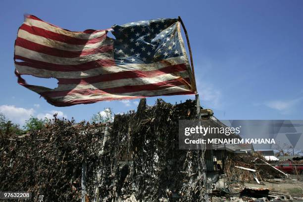 Tattered US flag waves on a pole in the devastated Ninth ward of New Orleans, Louisiana 21 September 2005, most of the neighborhood was flooded and...