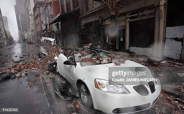 Cars damaged from falling debris stand in the French Quarter of New Orleans 29 August 2005 after Hurricane Katrina made landfall near the Louisiana...