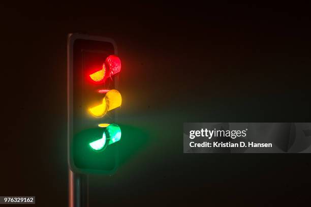 traffic light on foggy night - semaforo fotografías e imágenes de stock