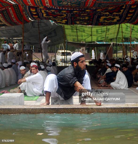 Pakistani Muslim man performs ablutions as he arrives to attend Friday prayers at the Red Mosque in Islamabad on July 10 the second anniversary of a...