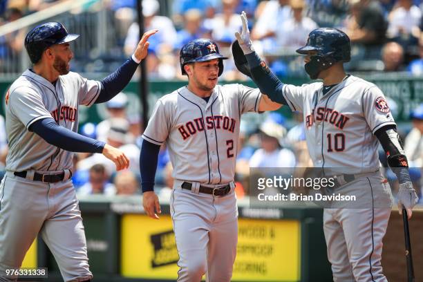 George Springer and Alex Bregman of the Houston Astros celebrate with Yuli Gurriel after scoring on a double in the first inning against the Kansas...