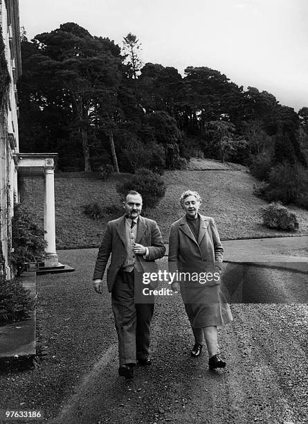 English writer Dame Agatha Christie, and her husband Max E. L. Mallowan, walk in March 1946 in the ground of their home, Greenway House, in...