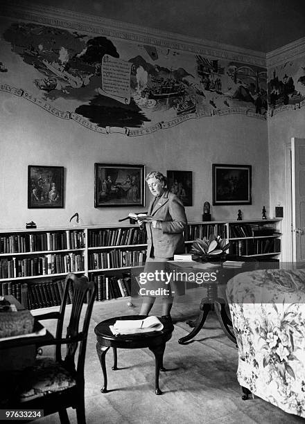 English writer Dame Agatha Christie, reads in March 1946 a book in the library of her home, Greenway House, in Devonshire. The frescoes on the wall,...