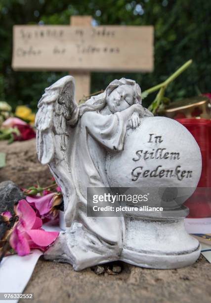 Dpatop - 07 June 2018, Germany, Wiesbaden: Candles, an angel statuette and personal messages of mourning lying near the site where the body of...