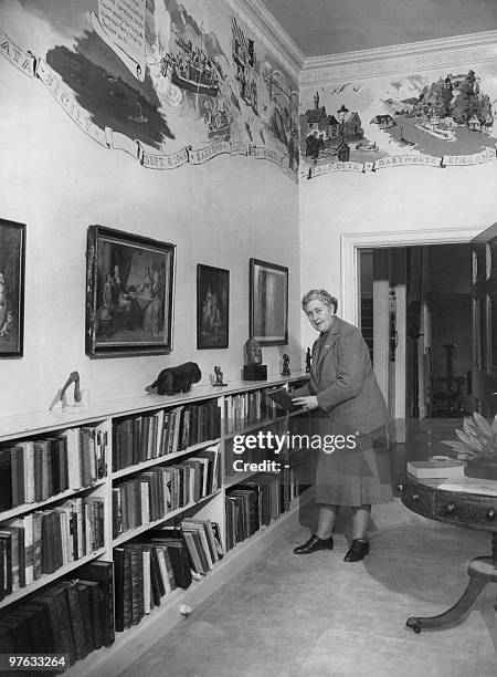 English writer Dame Agatha Christie, puts back in March 1946 a book on a shelf in the library of her home, Greenway House, in Devonshire. The...