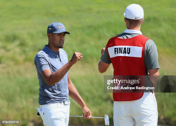 Tony Finau of the United States celebrates with caddie Greg Bodine after making a birdie putt on the 18th green during the third round of the 2018...