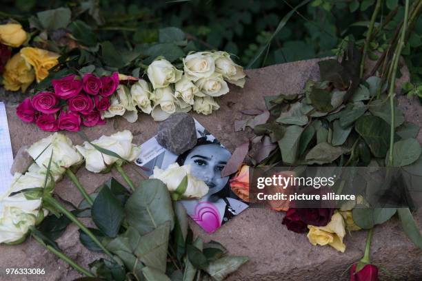 Dpatop - 07 June 2018, Germany, Wiesbaden: Candles, an angel statuette and personal messages of mourning lying near the site where the body of...