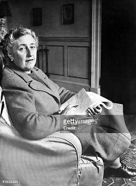English writer Dame Agatha Christie, poses in March 1946 for a photographer holding a notebook, in her home, Greenway House, in Devonshire. Agatha...
