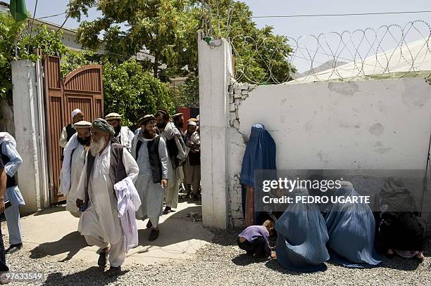 Afghan women wait for their husbands after a rally in support of incumbent president Hamid Karzai in Kabul on August 12, 2009. Afghans vote next week...