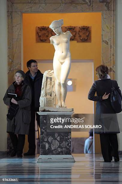Visitors look at a statue during the presentation to the press of "L'Eta della conquista. Il fascino dell'arte Greca a Roma" at the Capitoline...