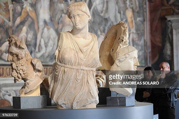 Visitors look at a head of Athena and other marble statues during the presentation to the press of "L'Eta della conquista. Il fascino dell'arte Greca...