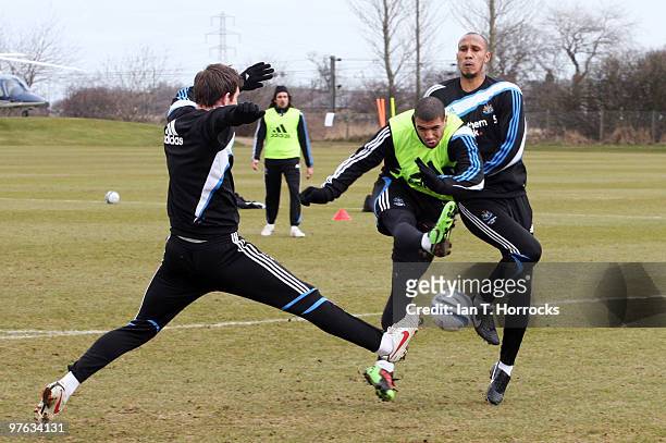 Leon Best of Newcastle shoots as team mate Mike Williamson and Fitz Hall attempt to block during a Newcastle United training session at the Little...