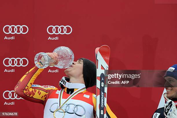 Overall winner Canada's Erik Guay kisses the globe beside Norway's Aksel Lund Svindal in the finish area after the men's Alpine skiing World Cup Supr...