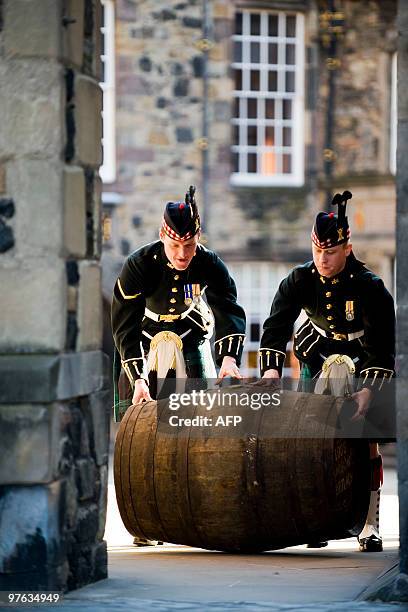 Soldiers push a barrell containing what is believed to be the world�s oldest bottled single malt whisky as it is launched at Edinburgh Castle, in...