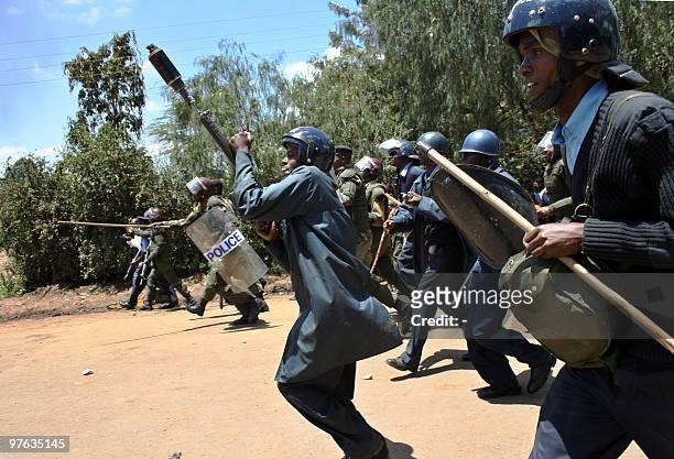 Kenya police charge to break-up a crowd of protesters who were burning tires on the main road March 11, 2010 to protest the killing of seven...