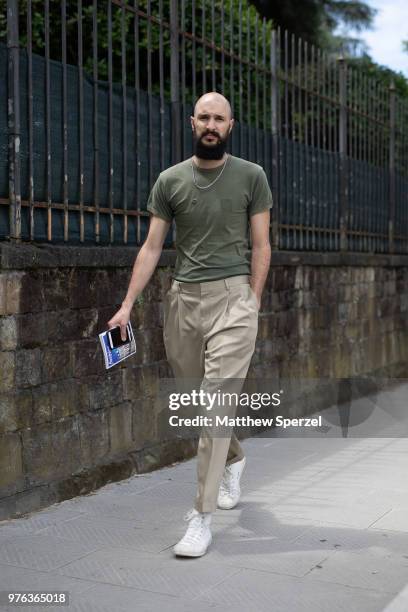 Guest is seen during the 94th Pitti Immagine Uomo wearing an army green shirt with khaki pants and white sneakers on June 14, 2018 in Florence, Italy.