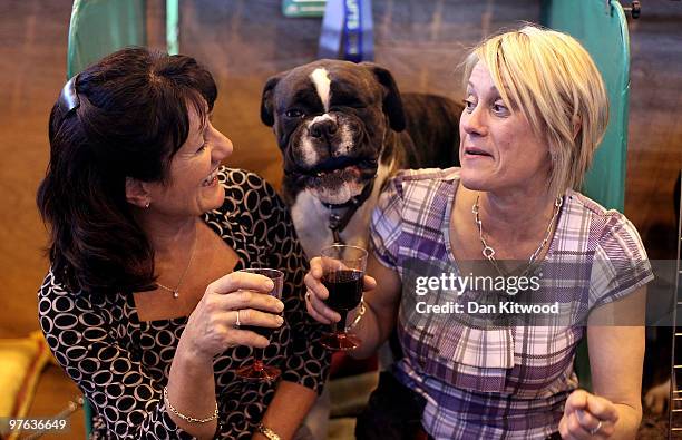 Two women and their dog wait by the practice arena on day one of the annual Crufts dog show at the National Exhibition Centre on March 11, 2010 in...