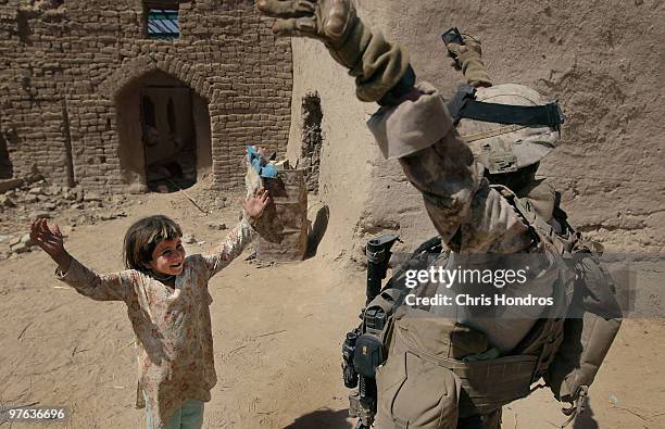 Marine Sgt. Henry Reyes of Ontario, California tries to teach a young Afghan girl gestures to the popular American dance song "YMCA" March 11, 2010...