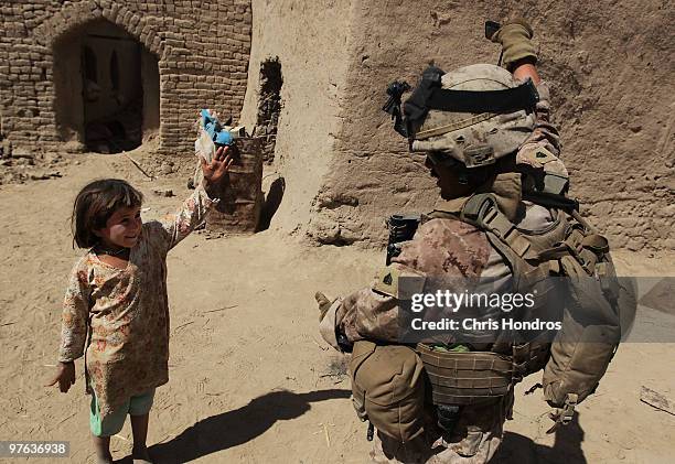Marine Sgt. Henry Reyes of Ontario, California tries to teach a young Afghan girl gestures to the popular American dance song "YMCA" March 11, 2010...