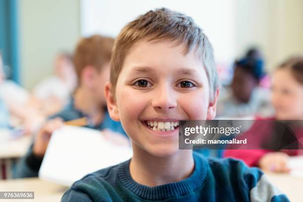 portrait d’étudiant s’asseoir dans la salle de classe pour le premier jour à l’école - sasseoir photos et images de collection