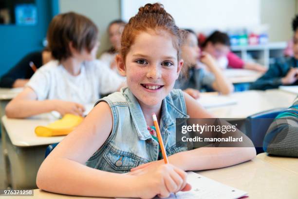 portrait d’étudiant s’asseoir dans la salle de classe pour le premier jour à l’école - sasseoir photos et images de collection