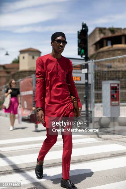 Guest is seen during the 94th Pitti Immagine Uomo wearing a red outfit with black shoes and brown bag on June 14, 2018 in Florence, Italy.