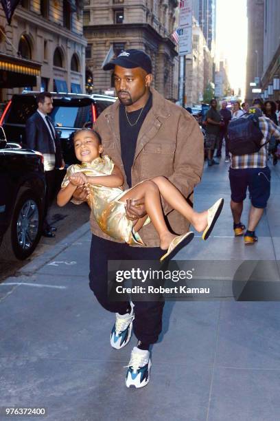 Kanye West seen carries daughter North West as they leave the Polo Bar Restaurant in Manhattan on June 15, 2018 in New York City.