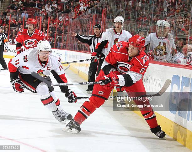 Tim Gleason of the Carolina Hurricanes skates along the boards and shoots the puck during a NHL game against the Ottawa Senators on March 4, 2010 at...