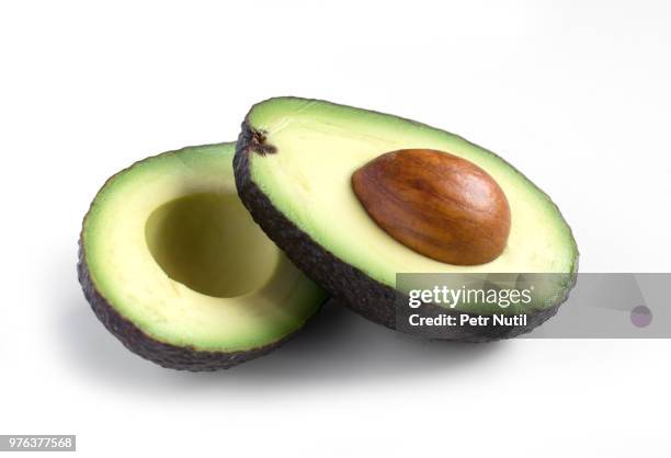 a fresh avocado cut in half - avocado isolated imagens e fotografias de stock