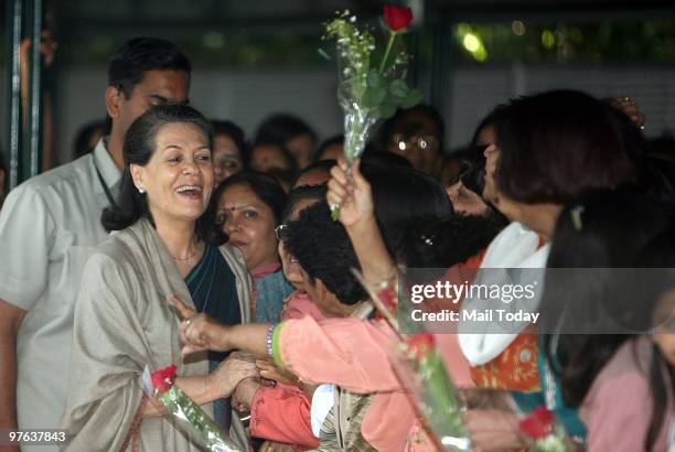 Party Workers greet Congress leader Sonia Gandhi for the passage of the women's reservation bill at her residence in New Delhi on March 10, 2010.