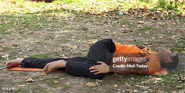 Yoga Expert Dinesh Dagar performs the Spinal Twist pose helpful in beating the exam stress in New Delhi on March 10, 2010.