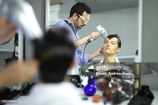 Model is prepared backstage ahead of the Les Hommes show during Milan Men's Fashion Week Spring/Summer 2019 on June 16, 2018 in Milan, Italy.