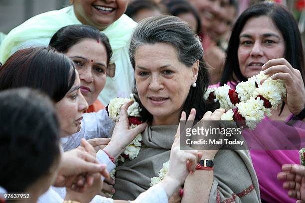 Party Workers greet Congress leader Sonia Gandhi for the passage of the women's reservation bill at her residence in New Delhi on March 10, 2010.