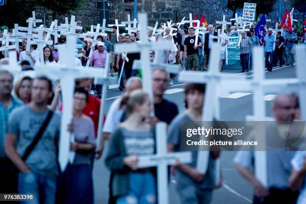 June 2018, Germany, Themar: A counter-demonstration against the rightist festival "Tage der nationalen Bewegung" with people carrying white crosses...