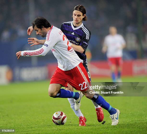 Ruud van Nistelrooy of Hamburg is challenged by Guillaume Gillet of Anderlecht during the UEFA Europa League round of 16 first leg match between...