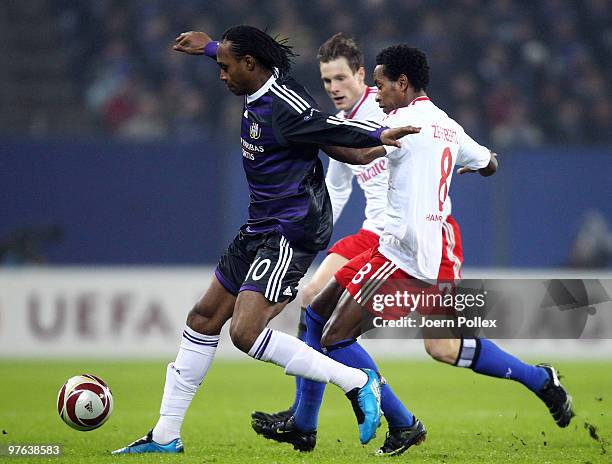 Ze Roberto and Marcell Jansen of Hamburg and Kanu of Anderlecht battle for the ball during the UEFA Europa League round of 16 first leg match between...