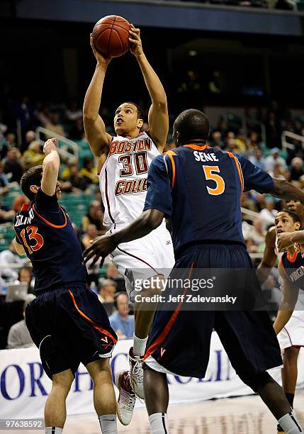 Dallas Elmore of the Boston College Eagles shoots between Sammy Zeglinski and Assane Sene of the University of Virginia Cavaliers in their first...