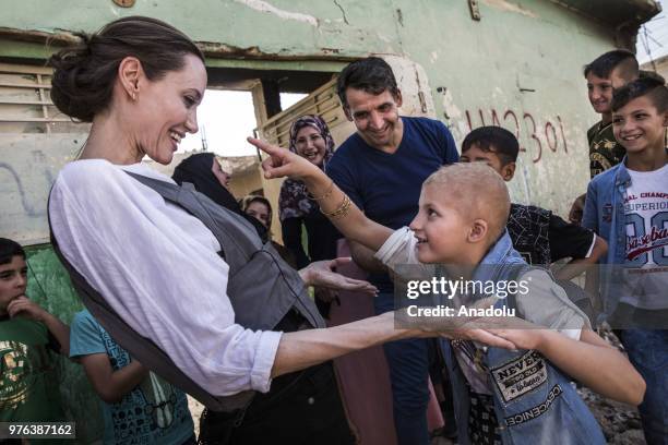 Actress and the UN refugee agency UNHCR Special Envoy Angelina Jolie takes care of a kid during her visit in Iraqs northern city of Mosul on June 16,...