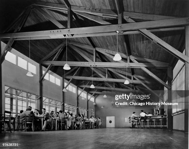 Low-angle view of students as they eat lunch in the cafeteria of a school in Oak Ridge, Tennessee, July 12, 1944. The city was established in 1942 to...