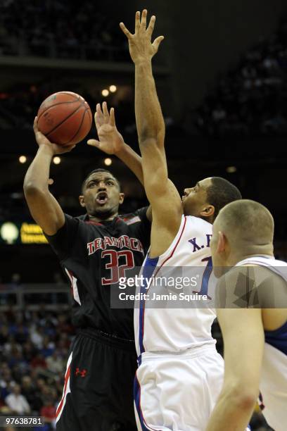 Mike Singletary of the Texas Tech Red Raiders goes up for a shot over Xavier Henry of the Kansas Jayhawks in the first half during the quarterfinals...