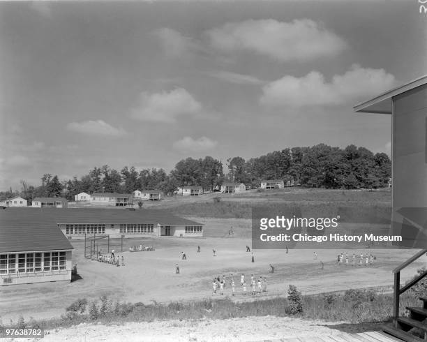 View of children on the baseball diamond and playground of a grade school in Oak Ridge, Tennessee, July 12, 1944. The city was established in 1942 to...