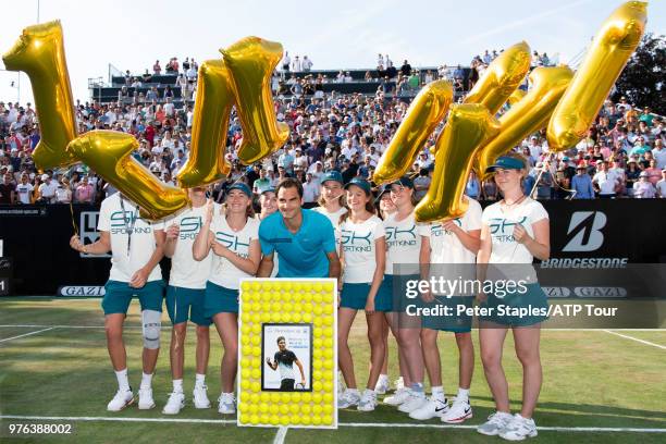 Roger Federer of Switzerland and the ball kids with a presentation for regaining the world number one title after his Semi-Finals match win against...