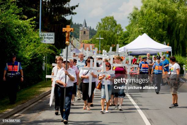 June 2018, Germany, Themar: Demonstrators protesting against the right-wing festival "Tage der nationalen Bewegung" carrying white crosses in Themar....