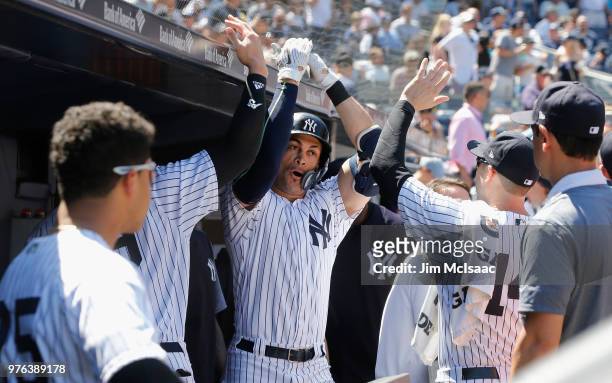 Giancarlo Stanton of the New York Yankees celebrates his fifth inning home run against the Tampa Bay Rays with his teammates in the dugout at Yankee...