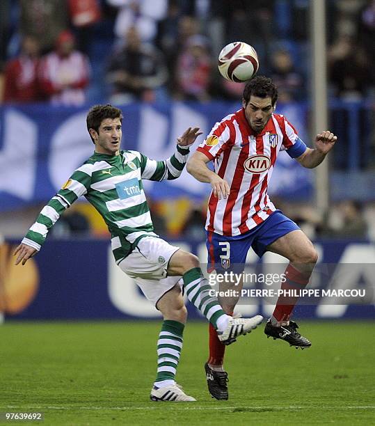 Atletico Madrid's captain Antonio Lopez vies with Sporting's midfielder Bruno Pereirinha during their Europa League football match at Vicente...
