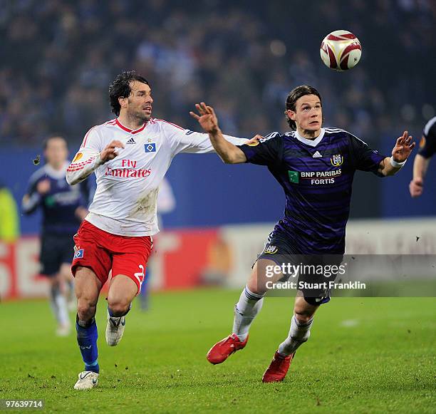 Ruud van Nistelrooy of Hamburg is challenged by Guillaume Gillet of Anderlecht during the UEFA Europa League round of 16 first leg match between...