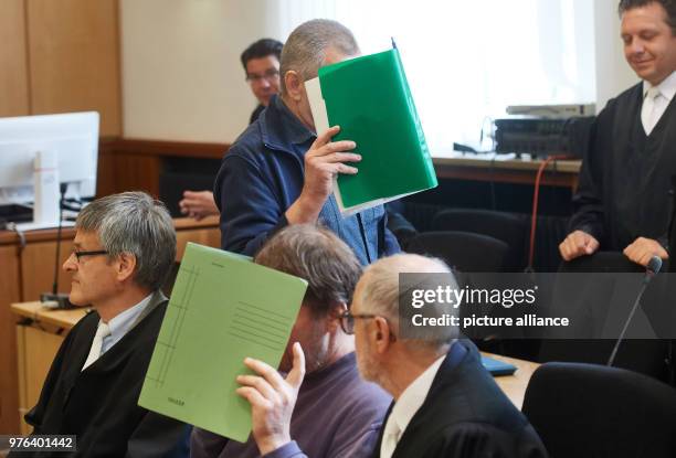 June 2018, Hagen, Germany: One of the defendants hides his face during the trial regarding 15 cases of robbery against money transporters. Seven...