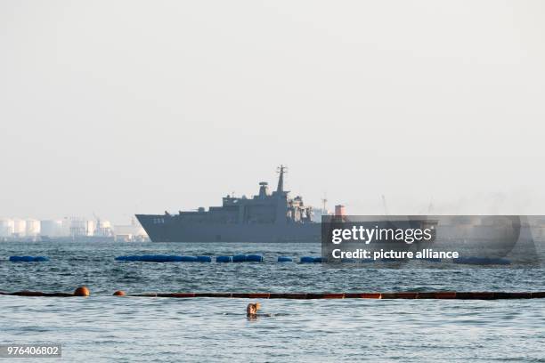 June 2018, Singapore, Singapore: A woman swims in front of a navy ship that lies at anchor off the coast of Sentosa Island. The summit meeting of US...