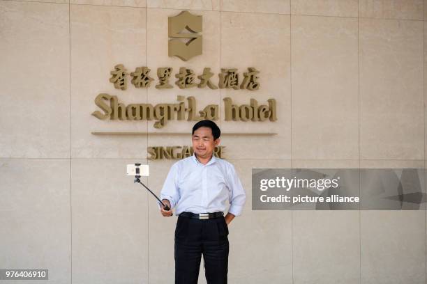 Dpatop - 11 June 2018, Singapore, Singapore: A man takes a selfie outside the Shangri-La-Hotel, where US President Trump is staying. The summit...